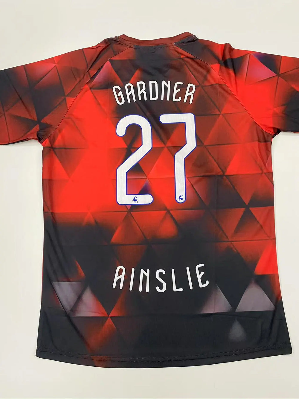 Crimson and black flame gradient soccer jersey with number 27
