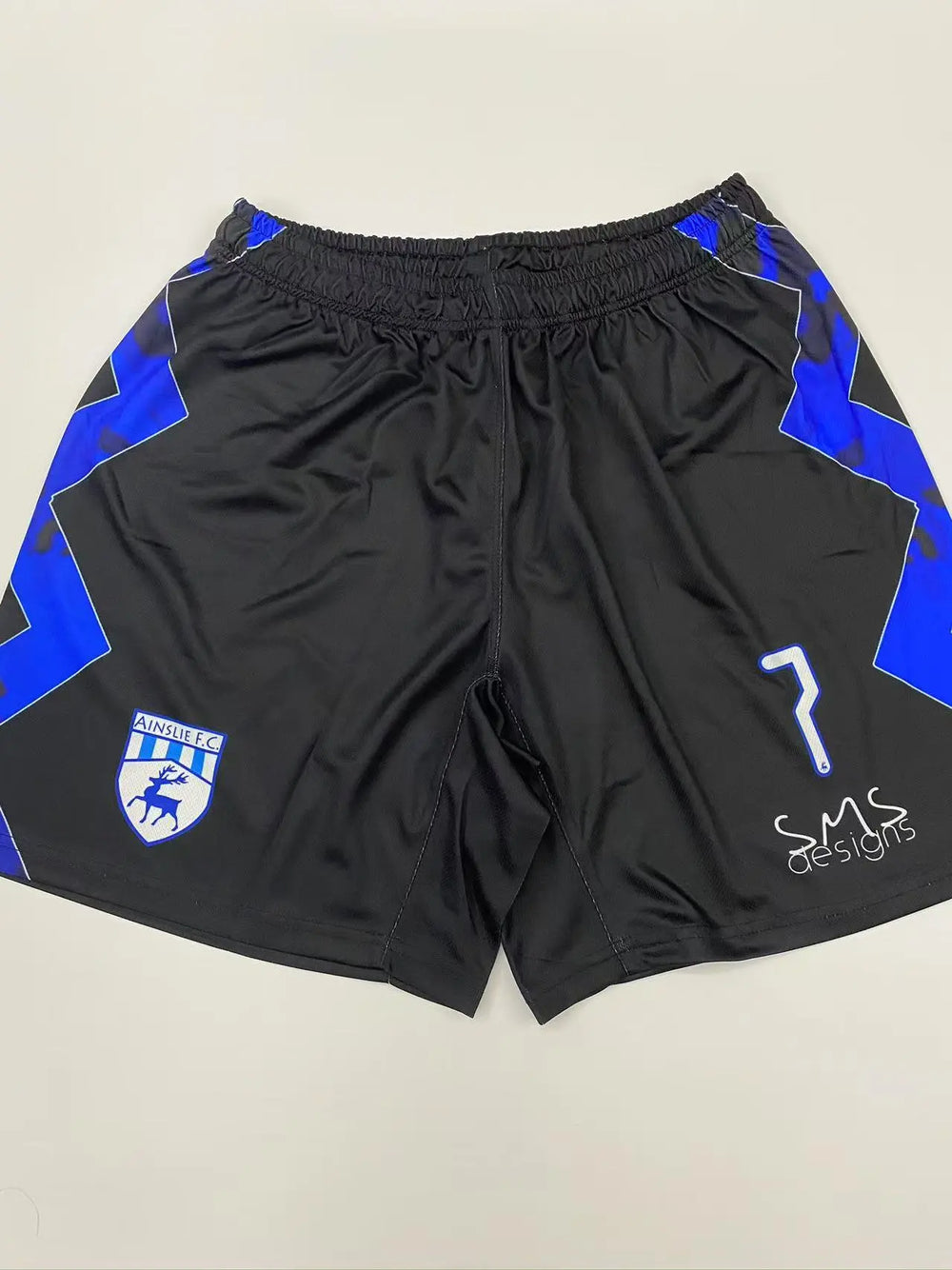 Black custom soccer match shorts with blue trim and crest